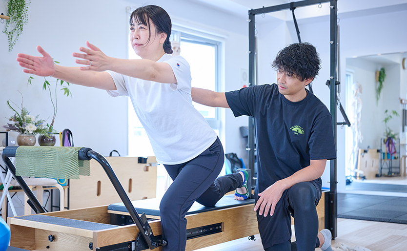 健康維持を目的にピラティスマシンで運動する様子