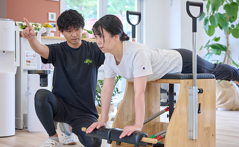 ピラティスマシンを使ったオーダーメイドのプログラムを指導する様子