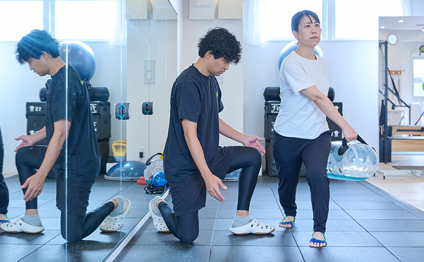 マットの上で日常動作につながる身体の使い方を指導する様子